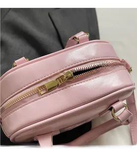 Detailed macro view of smooth golden zipper and pink glossy faux leather texture