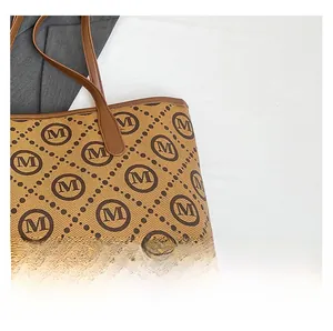 Détail du tissu jacquard à monogramme rétro et de la poignée en cuir marron d'un cabas