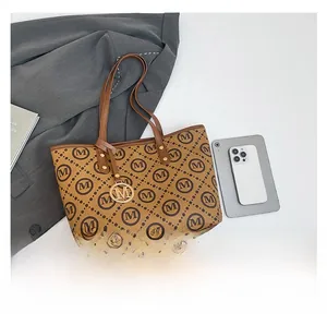 Détail du sac cabas vintage à monogramme marron avec breloque M dorée et accessoires