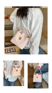 Detail showing pink leather bucket bag with gold clasp for handheld or crossbody wear