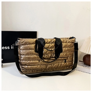 Détail du sac cabas matelassé doré avec fini métallisé et poche avant zippée