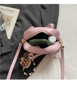 Pink leather handbag detail showing spacious interior with phone and cosmetics