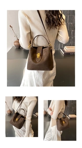 Detail of vintage brown leather bucket bag showing gold twist lock and adjustable strap
