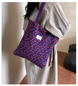 Detail of purple quilted tote bag showing textured 3D fabric and colorful dot pattern