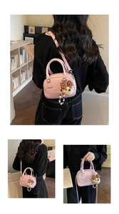 Pink Boston handbag with cute puppy charm shown in a cozy library setting