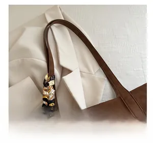 Detail of coffee brown tote handle wrapped with a decorative silk scarf and leopard texture