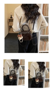Detail of dark brown vintage Boston bag with horse carriage logo and bear charm