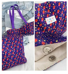 Close-up of blue wavy jacquard tote bag featuring metal magnetic clasp and brand label detail