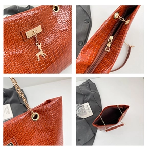 Detailed views of brown faux crocodile leather tote bag with gold chain and deer charm detail