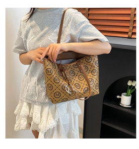 Détail du sac cabas marron avec imprimé monogramme M et pendentif métallique chic