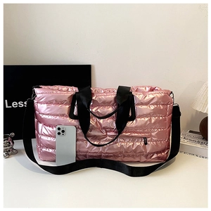 Détail du sac de voyage matelassé rose montrant la capacité avec un smartphone