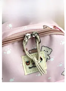 Detail of pink fabric backpack featuring cute bear prints and durable metal zippers