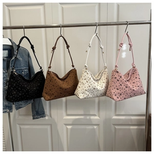 Detail view of four butterfly print hobo bags in black, brown, white, and pink finishes
