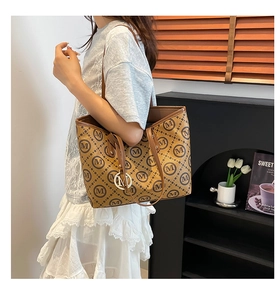 Détail d'un sac cabas marron avec motif M classique et breloque métallique élégante