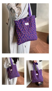 Close-up of pleated purple tote bag with colorful abstract pattern and brand label