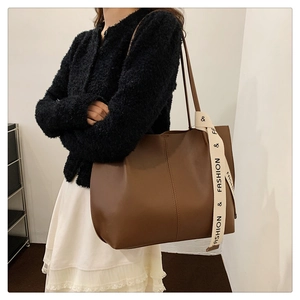 Detail of a large dark brown faux leather tote bag with stylish &FASHION& ribbon