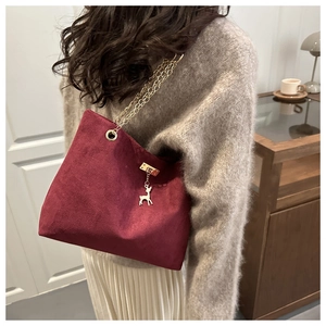 Détail du sac cabas en cuir bordeaux givré avec chaîne dorée et breloque cerf