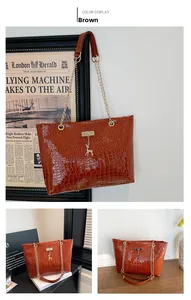 Detailed view of brown crocodile embossed tote bag with gold chain strap and deer pendant