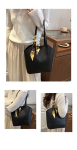 Detail der schwarzen Leder-Tote-Bag mit dekorativem gelbem bedrucktem Griffschal