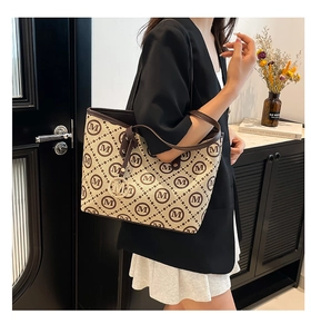 Détail du sac cabas matelassé avec imprimé M marron et pendentif logo en métal doré