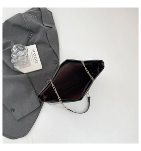 Close-up of black crocodile pattern bucket bag with gold chain and spacious interior