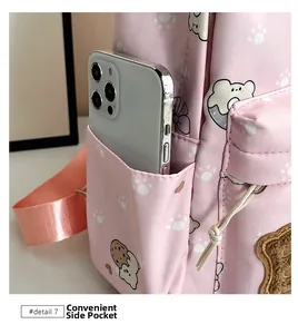 Close-up of portable elastic side pocket on pink cartoon backpack holding a smartphone