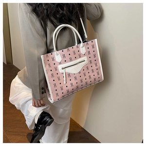 Detail of pink cartoon bear tote bag with white trim and zip pocket on model shoulder