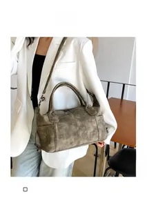 Dettaglio di una borsa a mano vintage verde oliva indossata da una modella elegante