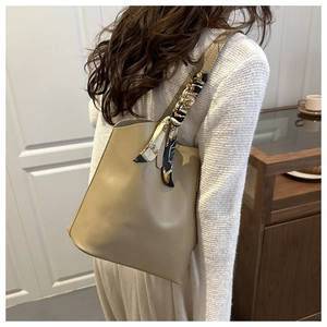 Close-up of khaki leather tote bag with vintage floral scarf on the shoulder strap