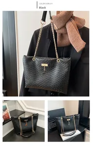 Detail of black crocodile texture tote bag with gold chain and deer pendant charm