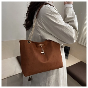 Détail du sac fourre-tout marron en simili daim avec chaîne dorée et pendentif cerf