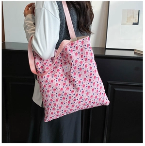 Detail of pink floral tote bag showing seersucker fabric and strap on model shoulder