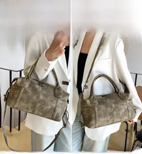 Dettaglio della borsa vintage marrone con rivetti in metallo e finitura in pelle martellata