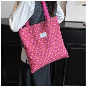 Detailed view of the pink floral knit tote bag featuring a stitched brand label