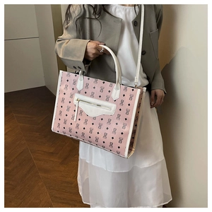 Detail of pink cartoon bear print tote bag featuring zip pocket and white shoulder straps