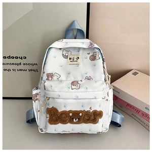 Close-up of cute white canvas backpack featuring cartoon bear patterns and 3D plush embroidery