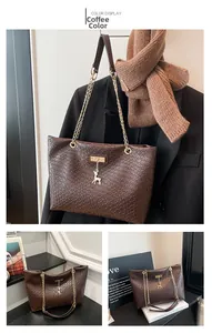 Detail of coffee brown woven tote bag with metallic deer charm and chain strap