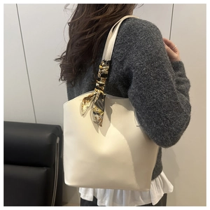 Creamy white tote bag with silk scarf detail worn by model for daily commuting