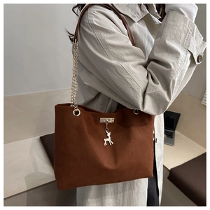 Détail du sac cabas vintage marron avec breloque cerf argentée et bandoulière chaîne
