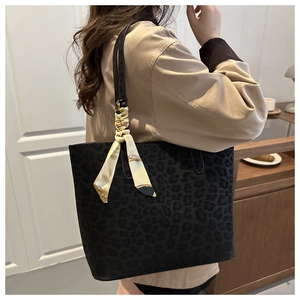 Black leopard print suede tote bag with silk scarf detail shown on female model shoulder