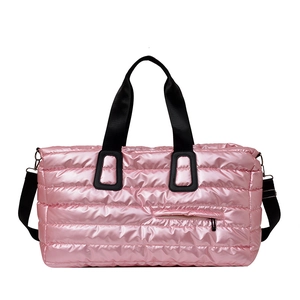 Sac de voyage matelassé rose avec finition métallique et bandoulière noire réglable