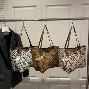 Set of three printed tote bags with matching pouches and thin leather handles on display