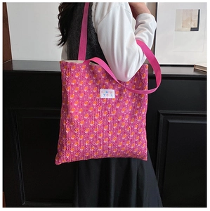 Close-up of pink floral tote bag featuring a square fabric label and pleated texture finish