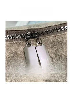 Dettaglio della doppia cerniera in metallo su borsa tote vintage con trama satinata