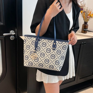 Grand sac cabas en toile avec bordure en cuir bleu marine et élégant pendentif doré