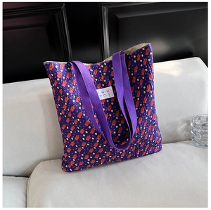 Detailed close-up of purple bubble textured tote bag featuring pixel pattern and brand label