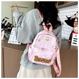 Detail of pink cartoon backpack with bear embroidery and cat paw prints on waterproof fabric