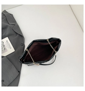 Detailed top view of black woven bucket bag with gold chain and spacious interior