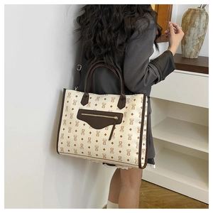 Detailed back view of a beige bear print tote bag with brown leather handles