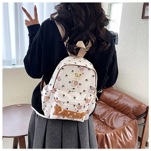 Detailed view of the creamy white canvas backpack with bear letters and cute cat paw prints